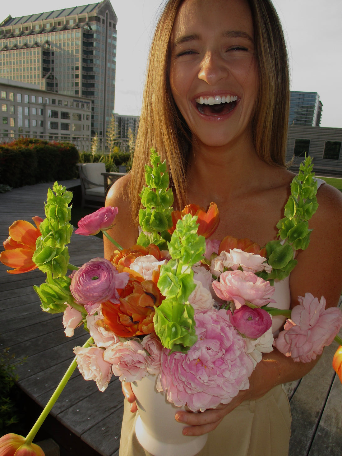 Mulher rindo com um buquê de flores
